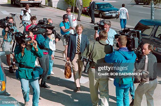 Attorney Dick DeGuerin is mobbed by photographers as he leaves his hotel on March 31, 1993 for his fourth face-to-face meeting in three days with...