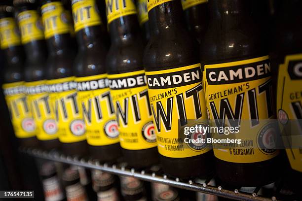 Bottles of Camden Town Brewery Co. Gentleman's Wit lemon-flavored craft beer sit inside a refrigerator in the company's brewery in London, U.K., on...