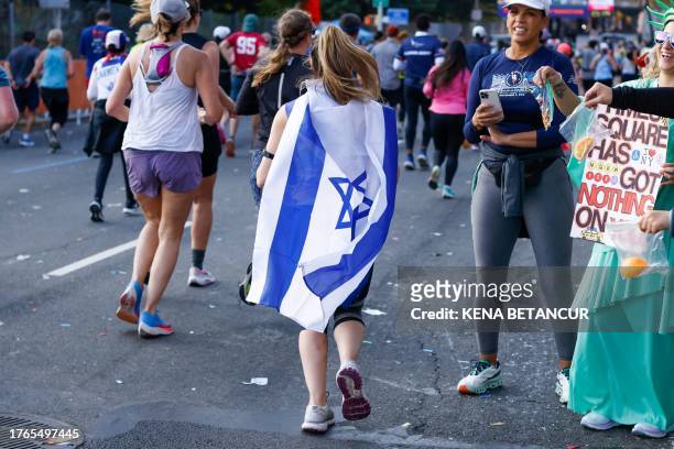Runner wears an Israeli flag as as she passes through the Bronx borough during the 52nd Edition of the New York City Marathon on November 5, 2023.