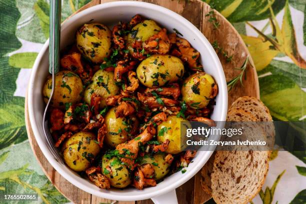 fried potatoes with chanterelles in a frying pan - cantharellus tubaeformis stock pictures, royalty-free photos & images