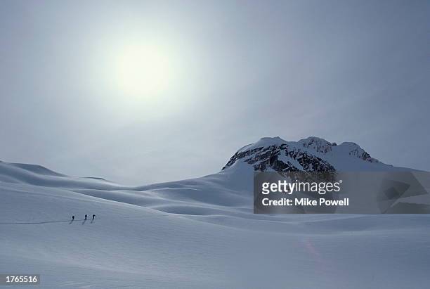 Three cross-country skiers crossing snowscape