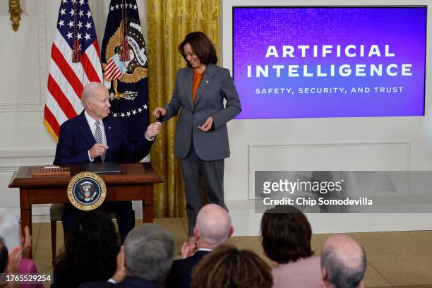 President Joe Biden hands Vice President Kamala Harris the pen he used to sign a new executive order regarding artificial intelligence during an...