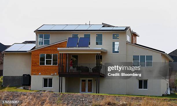 Solar electric panels and solar hot water panels sit on the roof of a Garbett Homes net zero energy house, which produces as much energy as it...