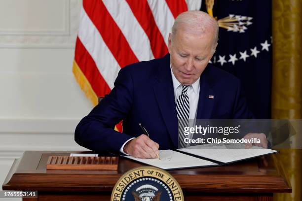 President Joe Biden signs a new executive order guiding his administration's approach to artificial intelligence during an event in the East Room of...