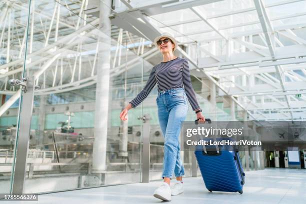 woman with her luggage at the airport - wheeled luggage stock pictures, royalty-free photos & images