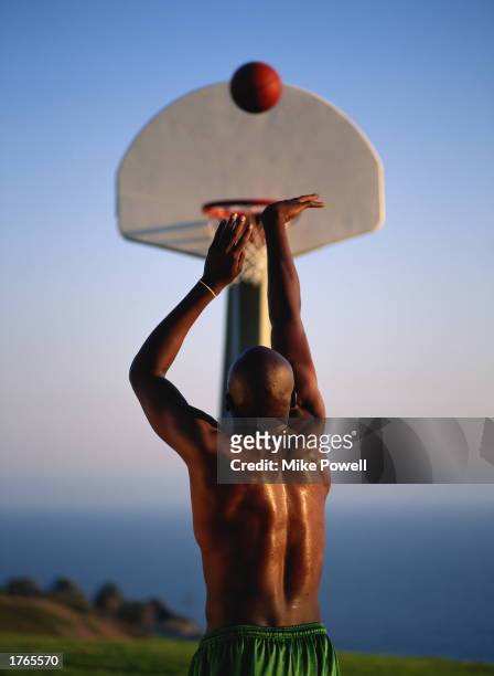 Basketball, male player placing ball in basket