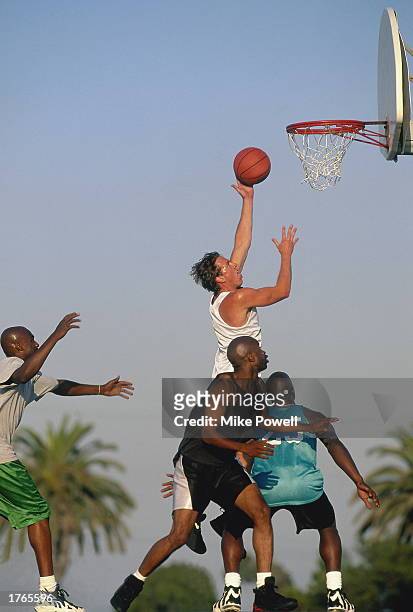 Basketball player jumping to put ball through basket