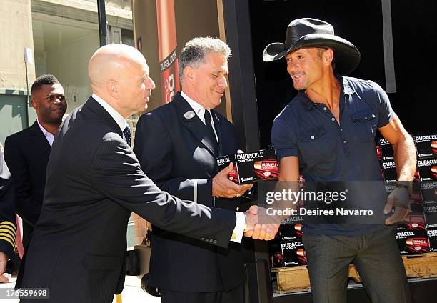 Singer Tim McGraw shakes hands with New York City Fire Commissioner Salvatore J. Cassano at the "Quantum Heroes" premiere at Engine 33, Ladder 9 on...