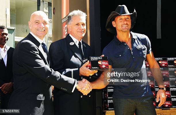 Singer Tim McGraw shakes hands with New York City Fire Commissioner Salvatore J. Cassano at the "Quantum Heroes" premiere at Engine 33, Ladder 9 on...