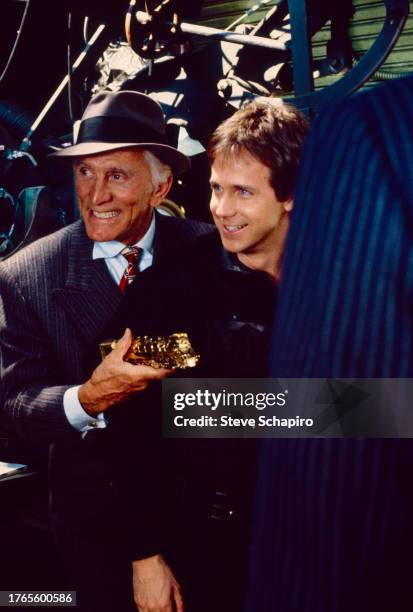 American actors Kirk Douglas and Dana Carvey as they smile together on set during the filming of 'Tough Guys' , Los Angeles, California, 1985.