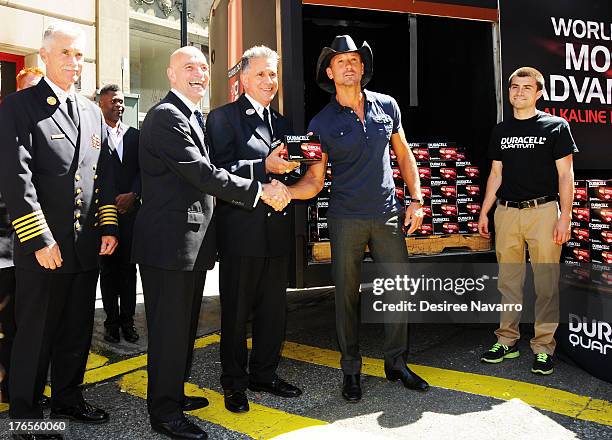 Singer Tim McGraw shakes hands with New York City Fire Commissioner Salvatore J. Cassano at the "Quantum Heroes" premiere at Engine 33, Ladder 9 on...