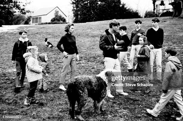 Married American couple, socialite Ethel Kennedy and politician & US Senator Robert F Kennedy , play football with their children on the grounds of...
