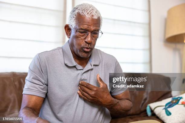senior black man with chest pain pointing to his chest - chest pain stock pictures, royalty-free photos & images