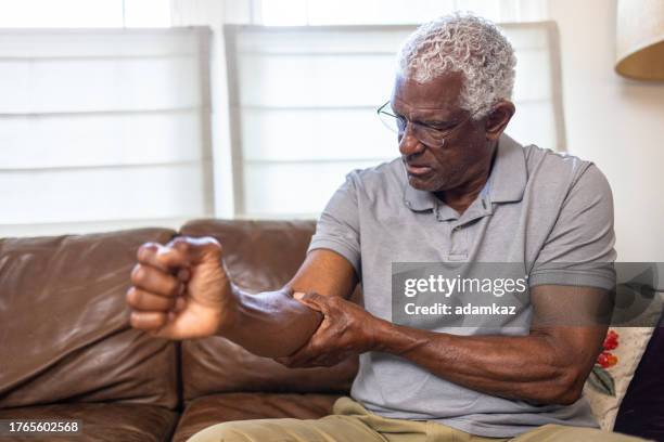 senior black man with elbow joint pain - elbow stock pictures, royalty-free photos & images