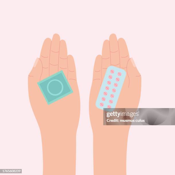 female hands holding birth control pills and condoms - contraceptive stock illustrations