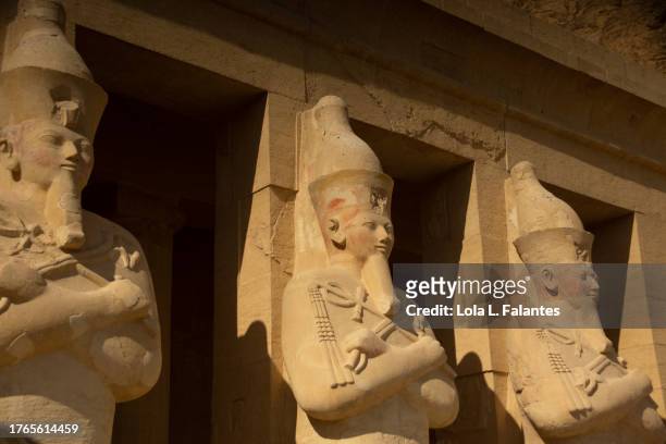 sculptures of queen hatshepsut with the attributes of a male pharaoh., including a false beard. mortuary temple of hatshepsut, luxor - queen cleopatra vii of egypt stockfoto's en -beelden