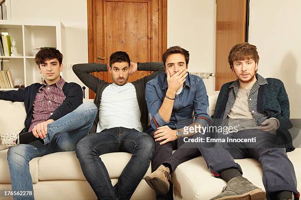 young men sitting on the sofa looking puzzled - quartet stock pictures, royalty-free photos & images