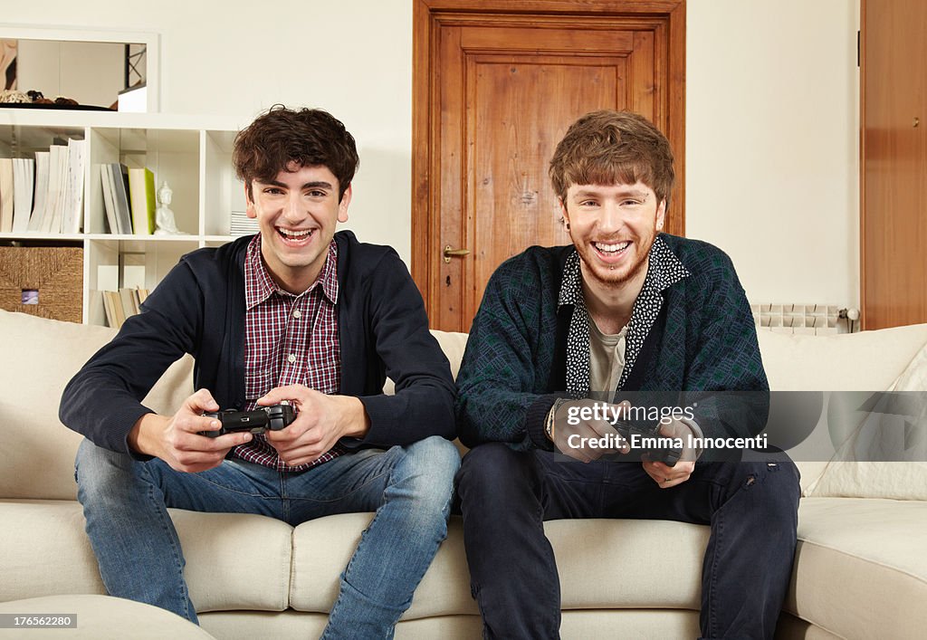 Two young men indoor playing video game