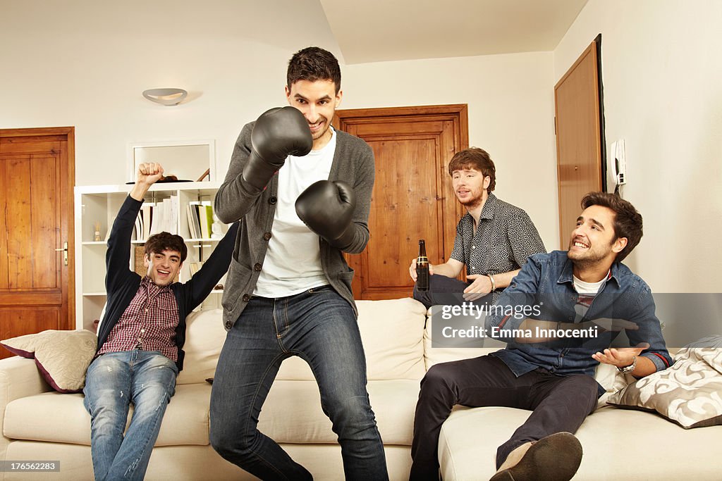Young men playing boxing with game console