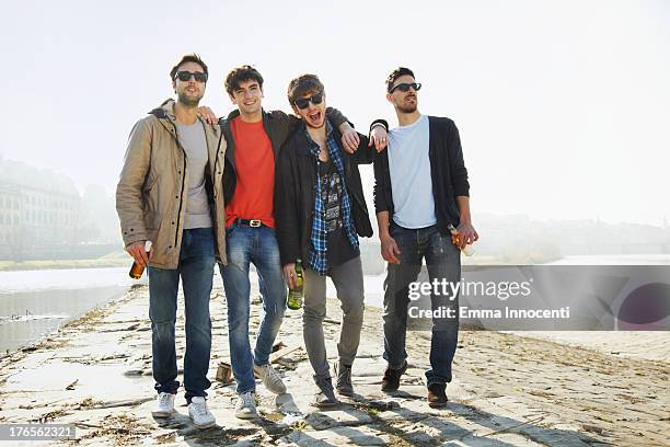 group of friends walking along the river - vier freunde stock-fotos und bilder