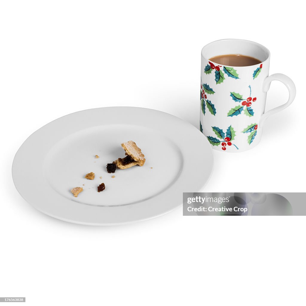 A plate of eaten mince pies and a cup of tea