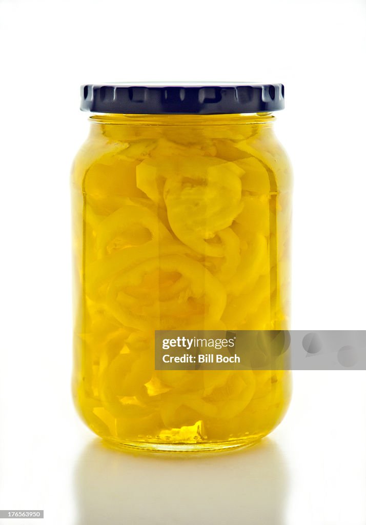 Banana pepper rings in a jar on white