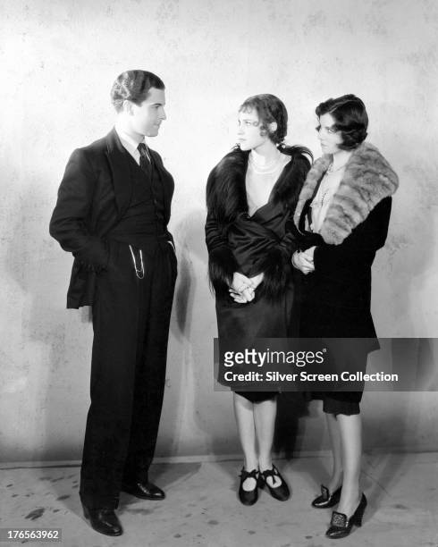 Mexican actor Ramon Novarro with two young women, circa 1925.