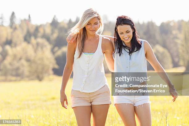 friends walking arm in arm outdoors - sleeveless top stock pictures, royalty-free photos & images