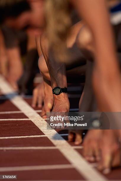 Athletes crouching on starting line, close-up