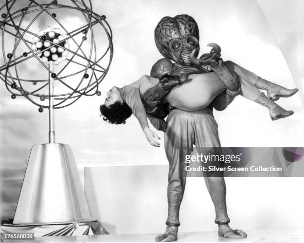 Faith Domergue as Dr. Ruth Adams in the clutches of the Mutant in a publicity still for 'This Island Earth', directed by Joseph M. Newman, 1955. The...