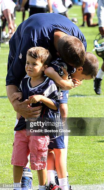 Tom Brady is greeted by his sons, Benjamin, left, and Jack as the New England Patriots end their last practice on Thursday, August 15 before the...