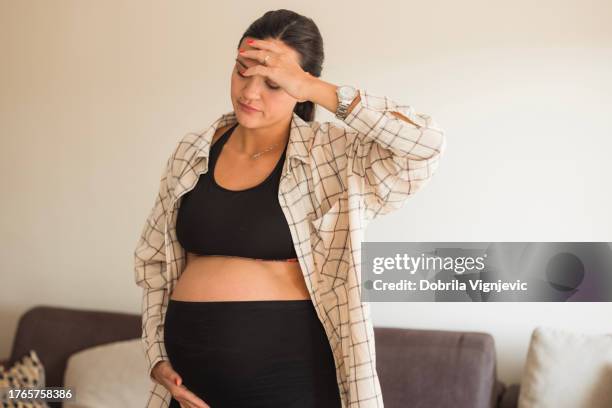pregnant woman with a headache - dizzy stock pictures, royalty-free photos & images