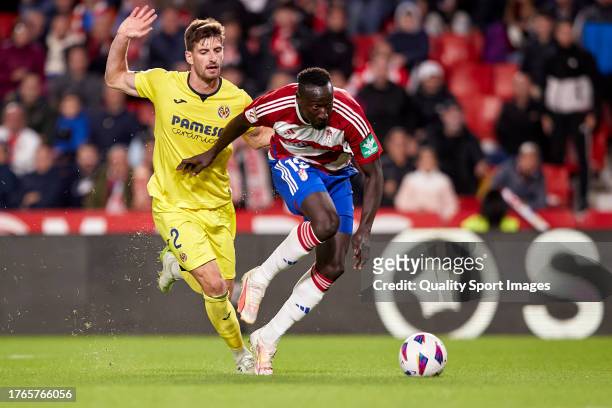 Famara Diedhiou of Granada CF competes for the ball with Matteo Gabbia of Villarreal CF during the LaLiga EA Sports match between Granada CF and...