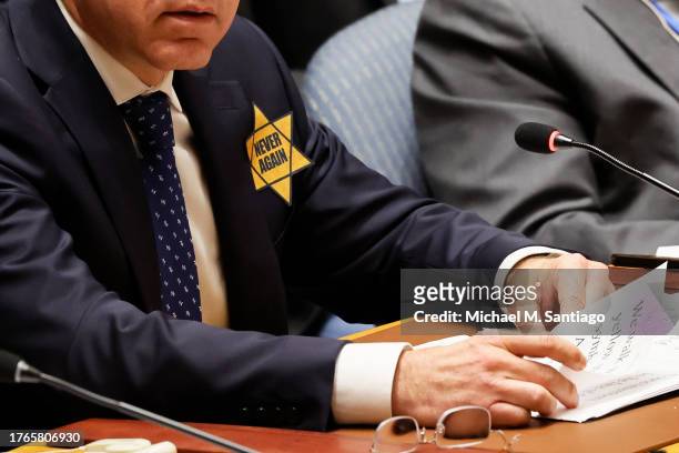 Yellow Star of David with the words "Never Again" is worn by Israel United Nations Ambassador Gilad Erdan as he speaks during a Security Council...
