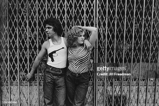 Couple lean against a shop shutter in Midtown Manhattan, New York City, 1979.