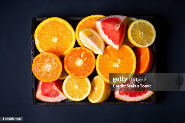 agrumi in un piatto di legno - vitamina c foto e immagini stock