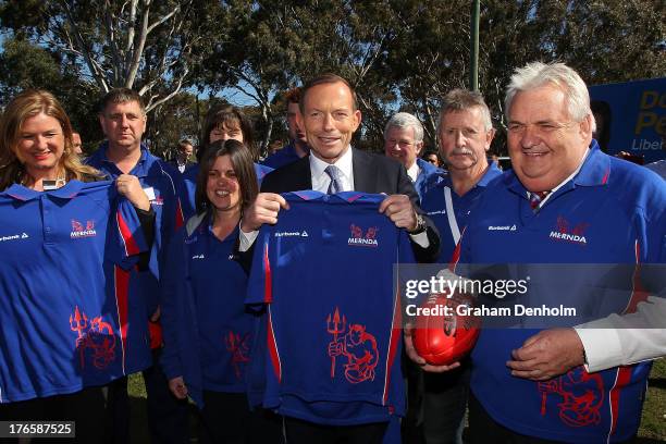Opposition leader Tony Abbott poses with Liberal candidate for McEwen Donna Petrovich and members of Mernda Football Club on August 16, 2013 in...