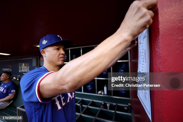 Associate manager Will Venable of the Texas Rangers posts the lineup in the dugout before Game Three of the World Series against the Arizona...