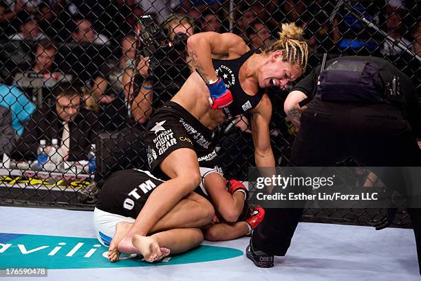 Cristiane 'Cyborg' Santos punches Gina Carano during the inaugural Strikeforce Women's Championship event at HP Pavilion on August 15, 2009 in San...