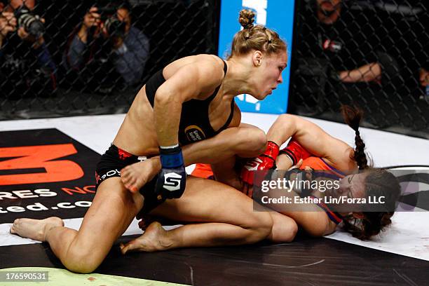 Ronda Rousey punches Miesha Tate during their bantamweight championship fight during the Strikeforce event at Nationwide Arena on March 3, 2012 in...