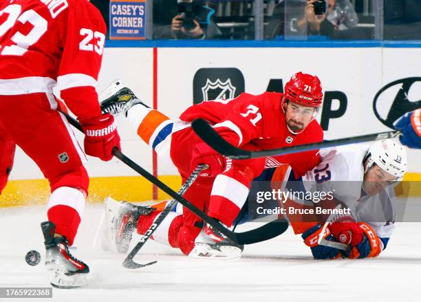 Dylan Larkin of the Detroit Red Wings battles with Mathew Barzal of the New York Islanders during the first period at UBS Arena on October 30, 2023...