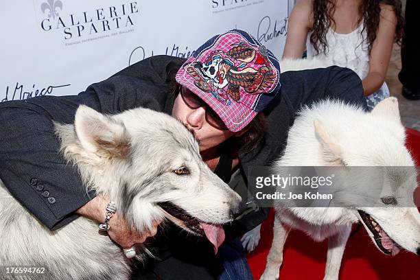 Actor David Fralick poses for a photo with Ranger a wolf from the Wolfconnection.org at Richard Grieco's opening night gala for his one-man art...
