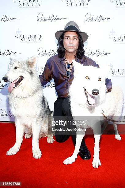 Actor/artist Richard Grieco poses for a photo with Ranger and Maya, wolfs from the Wolfconnection.org at Richard Grieco's opening night gala for his...