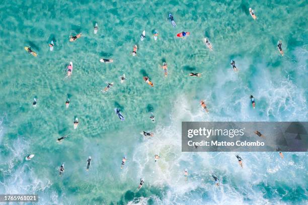 aerial view of surfers paddling out in the ocean - new south wales aerial stock pictures, royalty-free photos & images