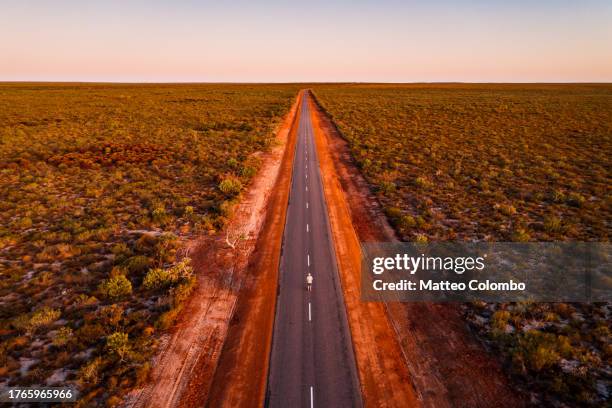 man standing in the middle of the road in the outback - western australia road stock pictures, royalty-free photos & images