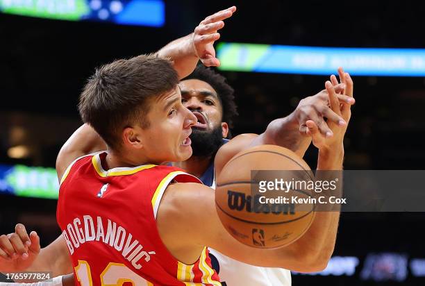 Bogdan Bogdanovic of the Atlanta Hawks battles for a rebound against Karl-Anthony Towns of the Minnesota Timberwolves during the first quarter at...