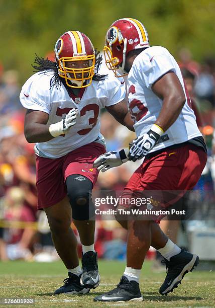 Washington guard Adam Gettis , left, closes in on fellow guard Chris Chester during the Washington Redskins practice on day 16 of summer training...