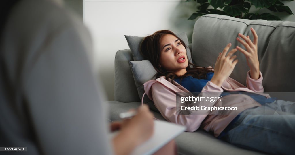 Asiatische Therapeuten schreiben Notizen während der Therapie mit einer Patientin