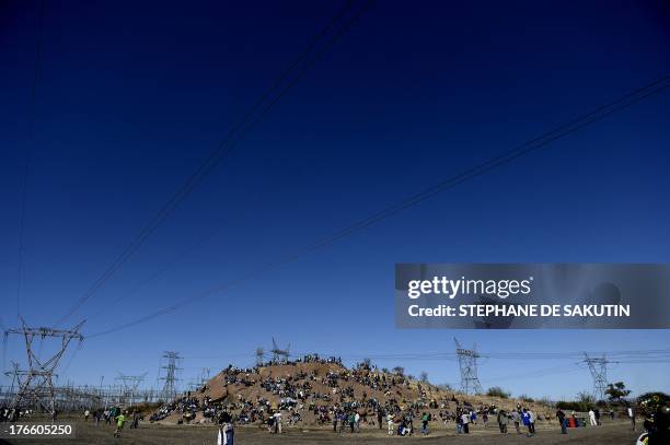 Co-workers and relatives of 34 miners shot dead by South African police during a violent wage strike gather on August 16, 2013 in Marikana to mark...