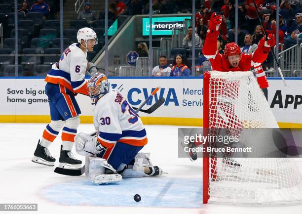 Lucas Raymond of the Detroit Red Wings celebrates a third period goal by Jake Walman against Ilya Sorokin of the New York Islanders at UBS Arena on...